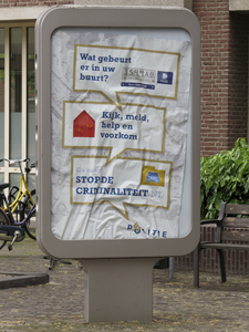 908099 Afbeelding van de verfrommelde affiche 'STOP DE CRIMINALITEIT', in een billboard op het pleintje voor het ...